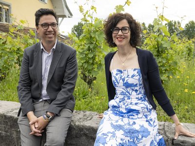 Les deux personnes posent assises sur un mur de vigne.