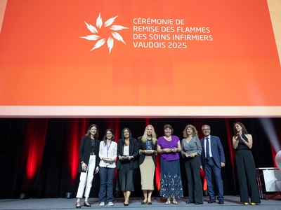 Les personnes posent sur scène. Les infirmières tiennent leurs trophées.