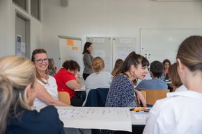 Des personnes assises, en discussion, dans une salle