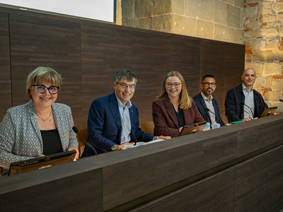 les personnes posent dans la salle de conférences de presse du château cantonal.