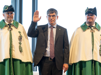 Il lève la main lors de la prestation, entre deux huissiers en grande tenue.