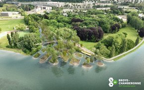 Vue aérienne au-dessus du lac. Une passerelle, des îlots plantés d'arbres.