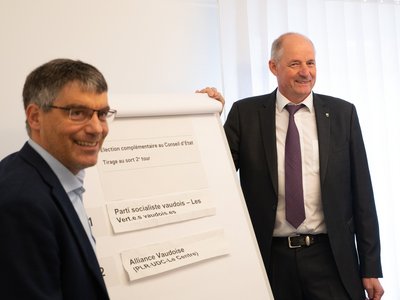 Les 2 candidats devant le panneau d'affichage du résultat du tirage au sort