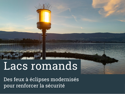 un feu à éclipse brille au bout de son mât au crépuscule dans un port vaudois du lac de Neuchâtel