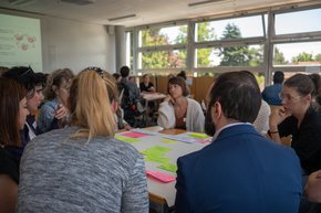 Des personnes assises, en discussion, dans une salle