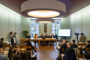 conférence de presse dans une salle de l'Hôtel de Ville d'Orbe. Les orateurs et oratrices sont au fond derrière une table. Les représentants des médias sont de dos.