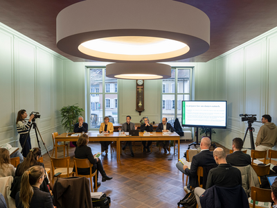 conférence de presse dans une salle de l'Hôtel de Ville d'Orbe. Les orateurs et oratrices sont au fond derrière une table. Les représentants des médias sont de dos.