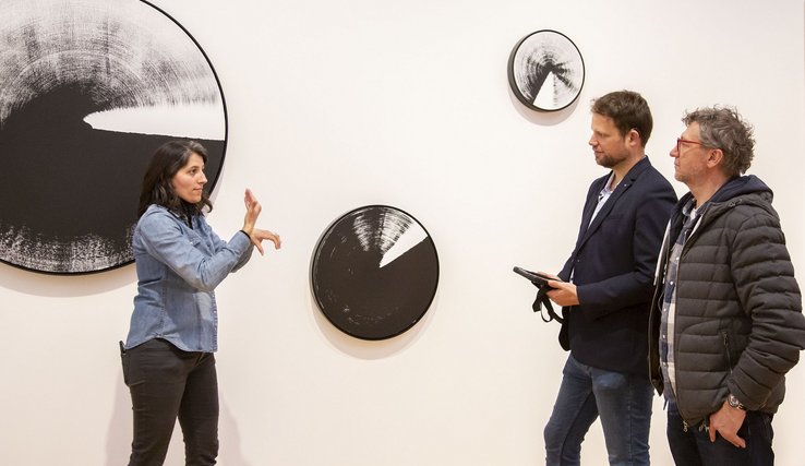 Photographie de 1) Noha El Sadawi, médiatrice culturelle sourde, présentant en langue des signes française une œuvre de l’exposition permanente du MCBA 