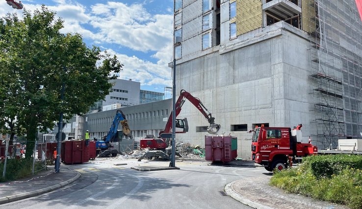 Vue de l'immeuble. Des engins évacuent des restes de l'échafaudage effondré.